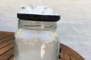 A picture of a jar with an artificial cloud inside, and ice on the lid